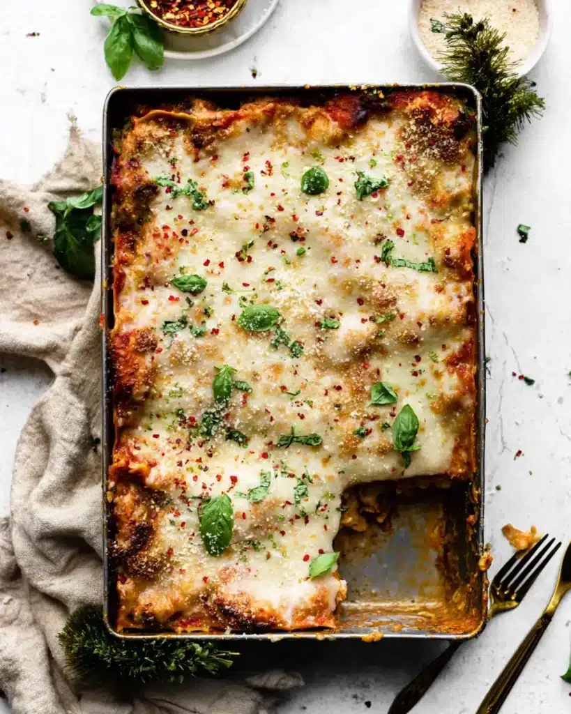 Baked Christmas Eve lasagna topped with melted cheese and herbs
