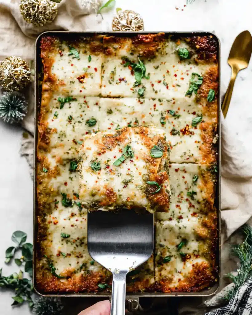 Slice of baked Christmas Eve lasagna being lifted from pan with melted cheese