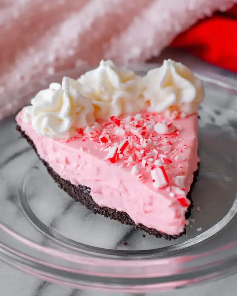 Slice of Christmas Peppermint Pie with whipped cream and crushed candy canes
