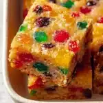 Golden fruitcake bar with colorful candied fruit pieces and chewy holiday texture