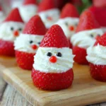 Cute strawberry Santas filled with cream cheese frosting on a wooden board