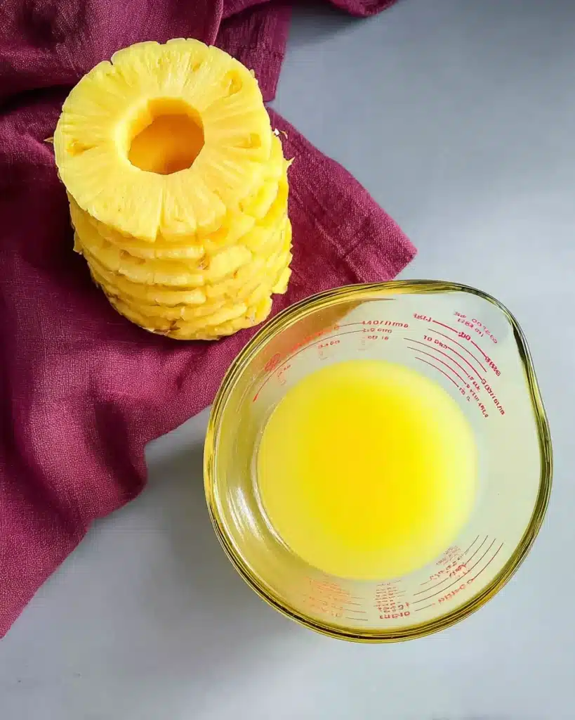 Pineapple rings and juice for baked ham glaze on gray surface
