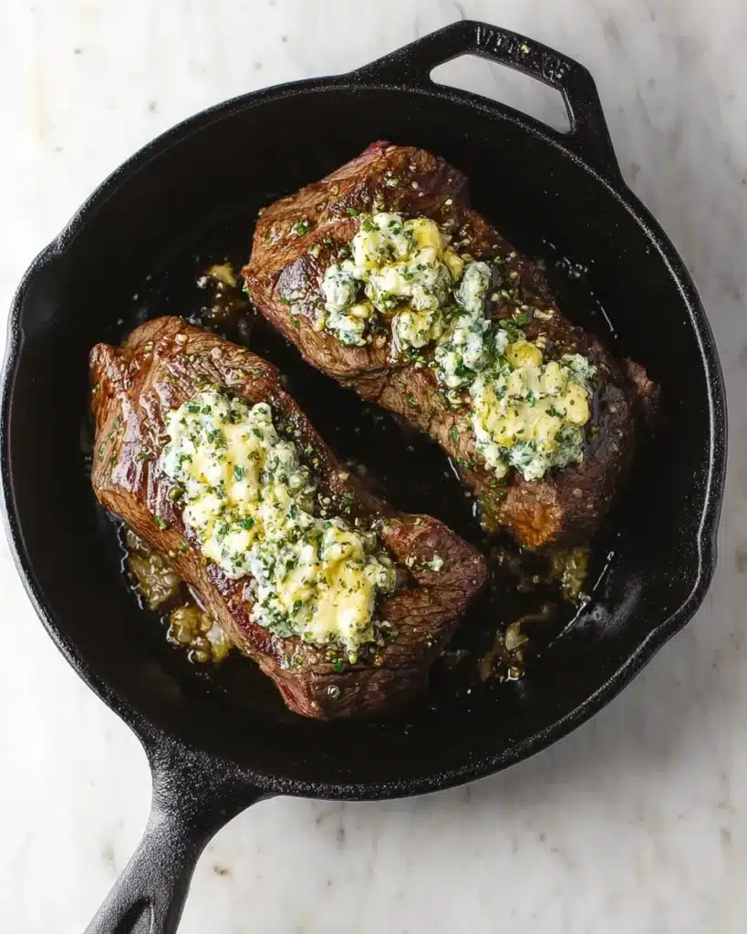 Seared beef tenderloin with garlic herb butter in skillet