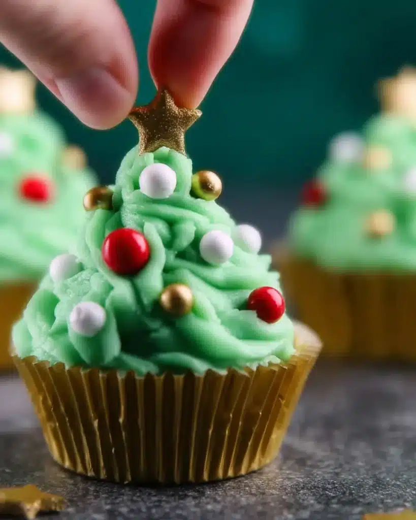 Decorating Christmas tree cupcake with green frosting and star topper
