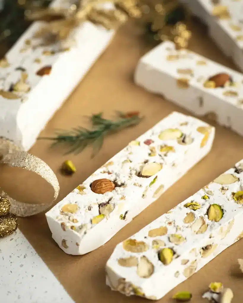 Homemade torrone nougat bars with pistachios on parchment paper